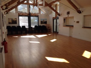 The empty main hall with its wooden floor and oak roof trusses