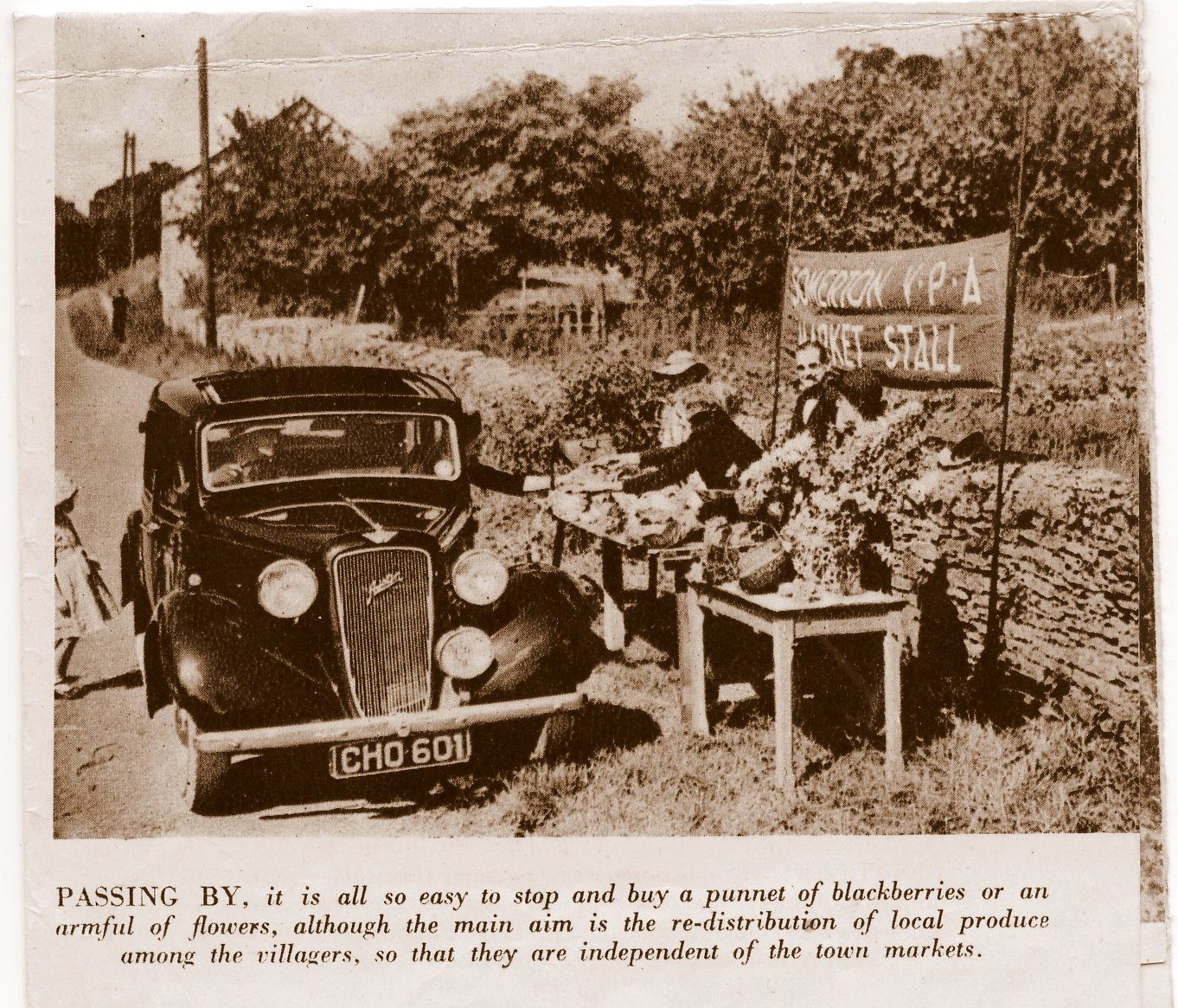 Newspaper photograph of the Somerton VPA market stall by the roadside, with a car stopped beside it